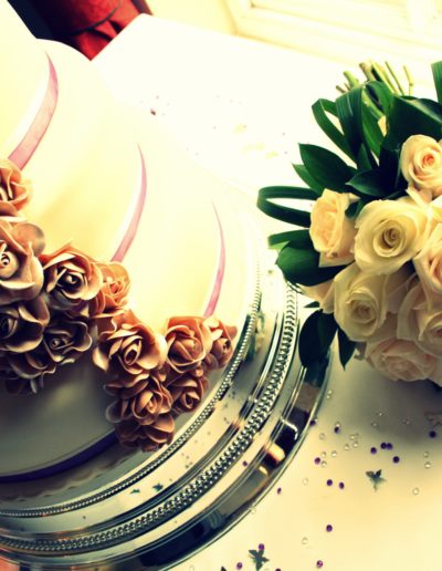 Traditional and Classic wedding cake on silver cake stand and flower bouquet on table