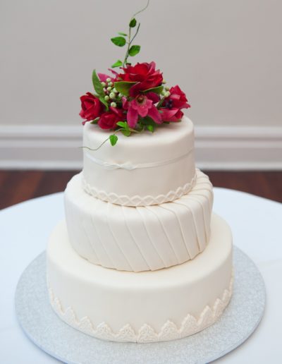 Traditional and Classic wedding cake on table with flowers on top