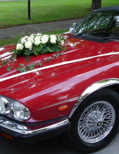Vintage wedding car with flowers on bonnet